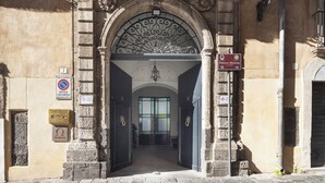 An entrance with a wrought iron gate, a sign for Palazzo Marletta, and a no parking sign.