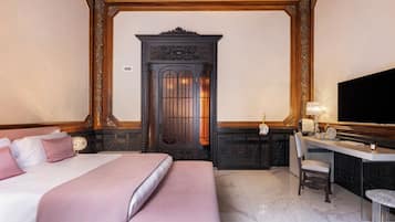 A hotel room with a bed, a desk with a chair, a television, and a decorative cabinet.