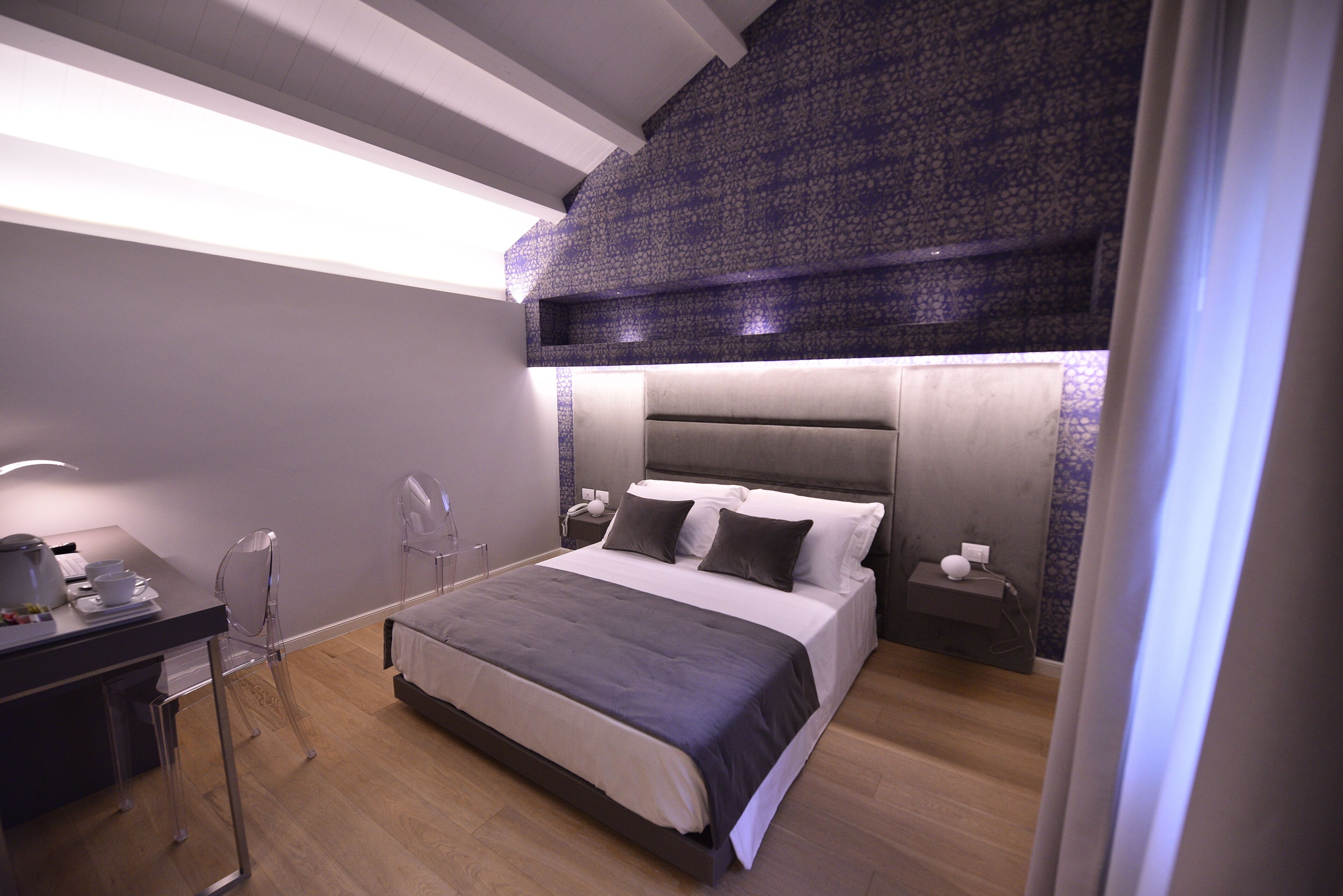 Une chambre moderne avec un grand lit, des tables de chevet, un bureau et une chaise.