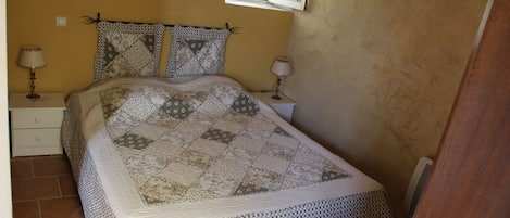 A bedroom with a bed, two nightstands, a window, and a door.