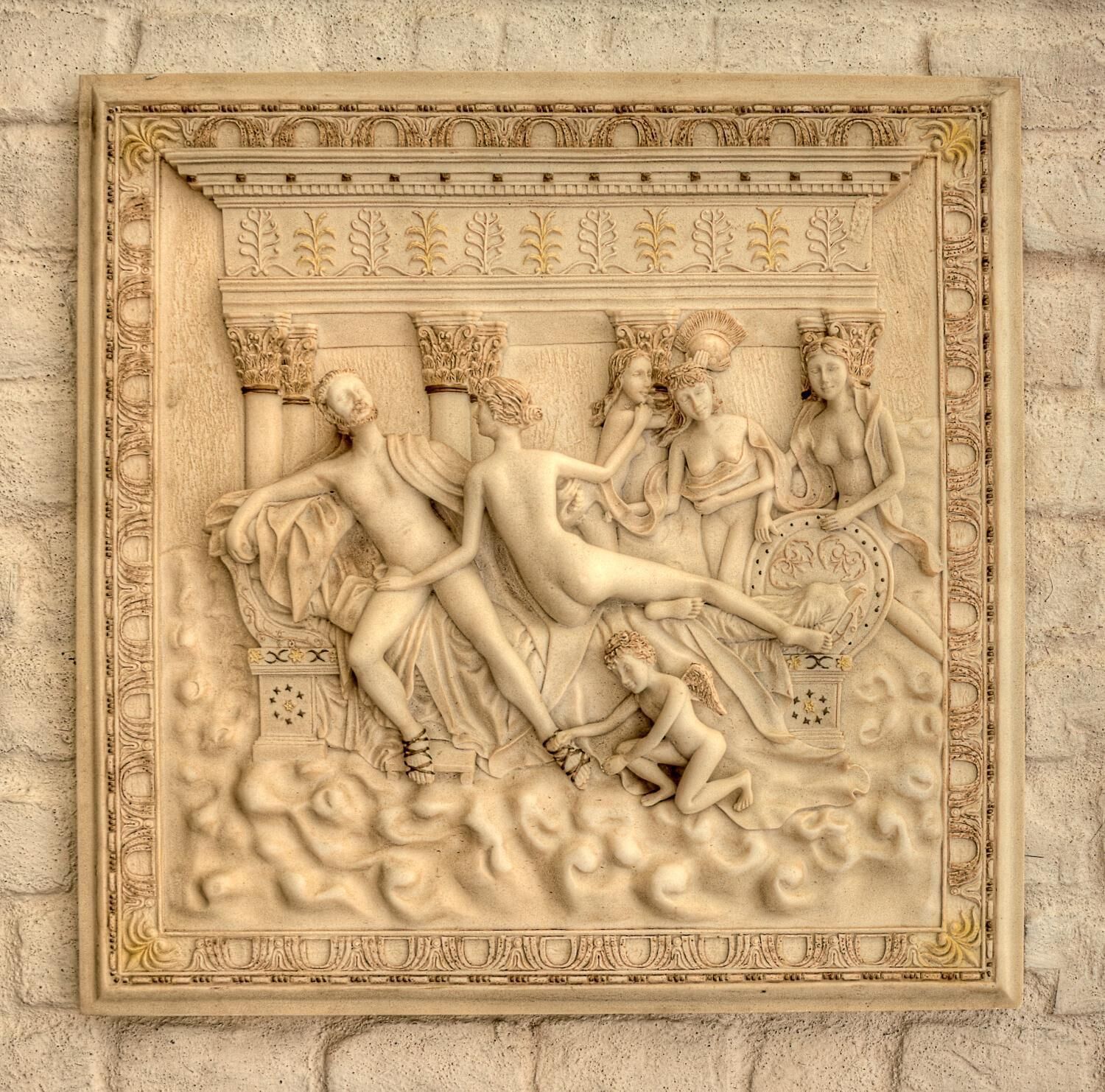 A detailed stone carving with classical figures and decorative elements.