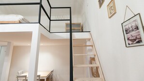 Un dormitorio estilo loft con una escalera de madera, un escritorio y una silla.