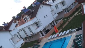 Une piscine rectangulaire dotée de plusieurs couloirs, entourée de chaises longues et de parasols.