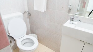 Un baño con inodoro, lavabo y espejo.