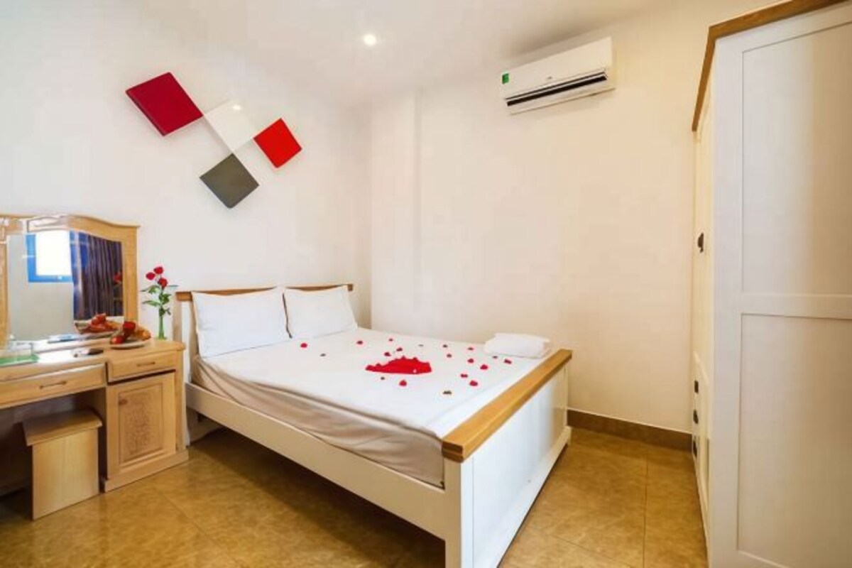 Une chambre d’hôtel avec un lit, un bureau et une armoire.