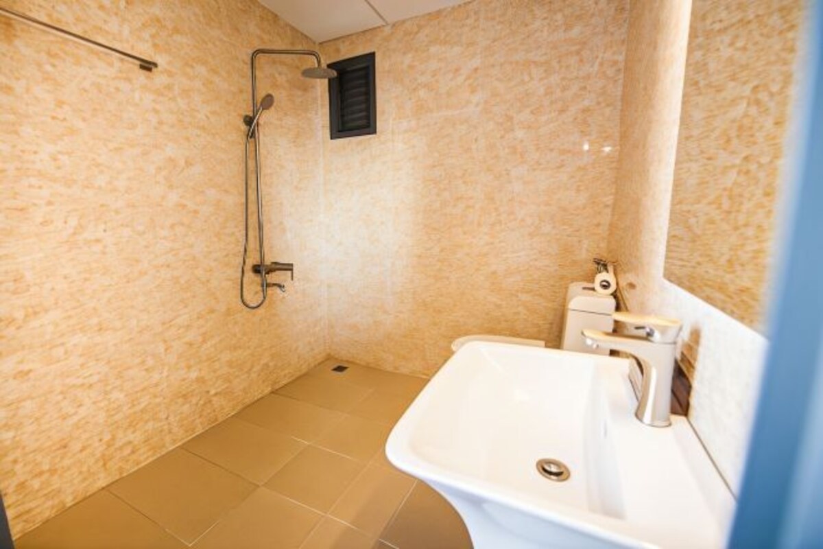 Une salle de bain avec une douche, un lavabo et un sol carrelé.