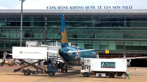An airport terminal with a large building and an airplane parked in front.