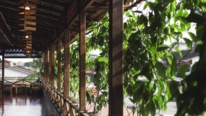 A covered walkway with wooden railings and potted plants. - House Of My Eternal Love - Kulai Homestay (Kulai)