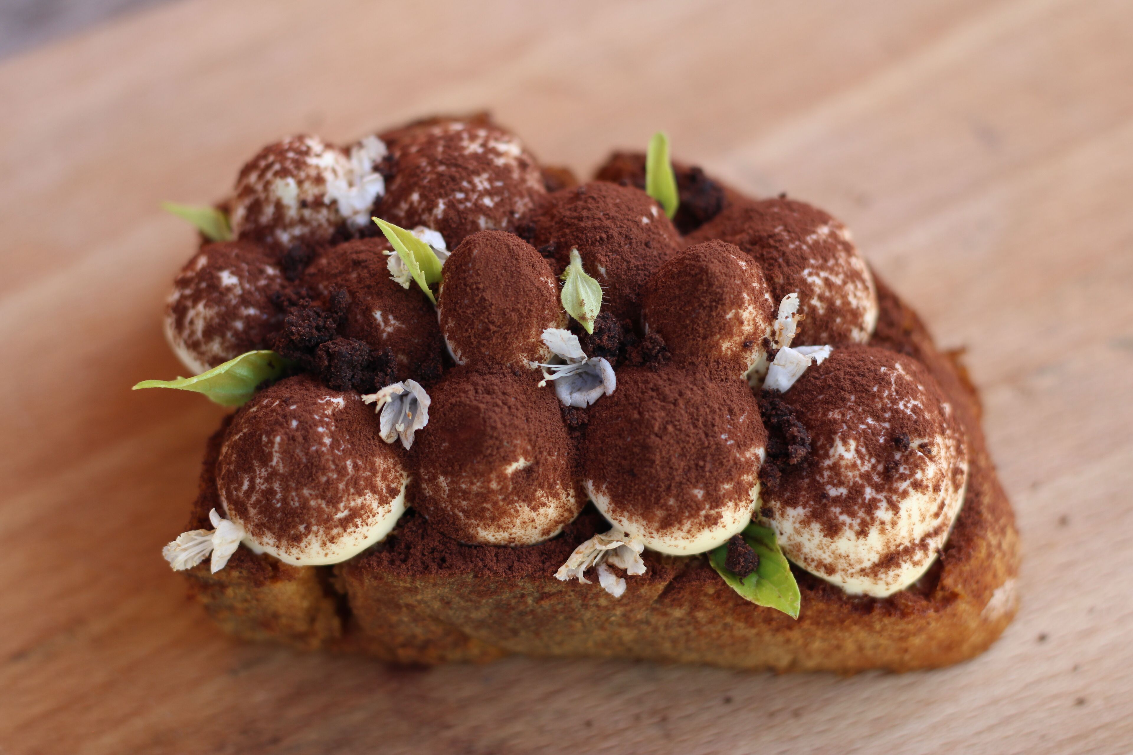 A dessert with chocolate-covered items on a wooden surface.