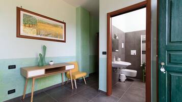 A bathroom with a sink, toilet, and shower area.