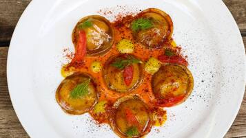 A white plate with a dish of stuffed vegetables, garnished with herbs and spices.
