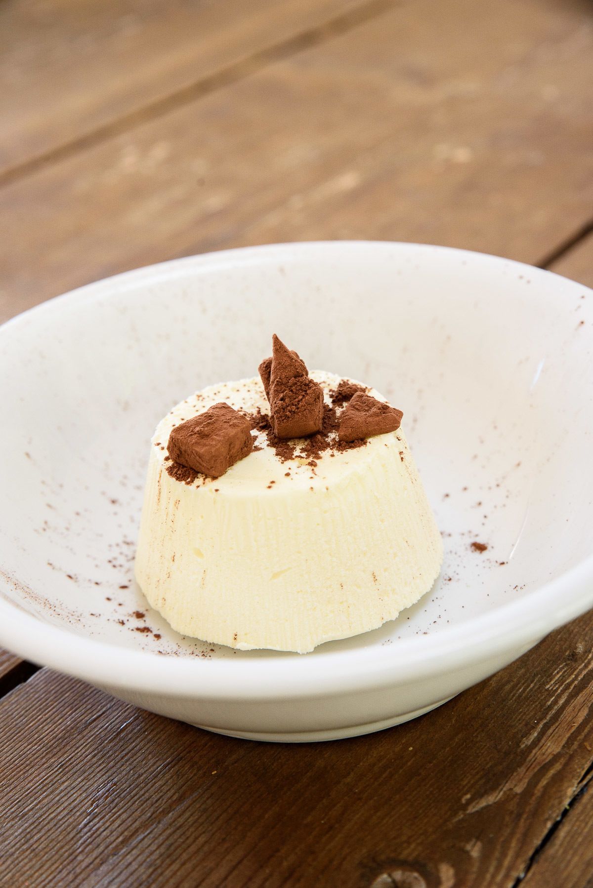A dessert on a white plate with a wooden background.