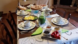 A breakfast table with plates of food, cups, and a pitcher of green juice. - Bed & Breakfast Dhafna Civita (Civita)