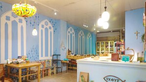 A cozy cafe interior with wooden furniture, a blue and white color scheme, and a fish-shaped sign. - Fish hostel (New Taipei City)