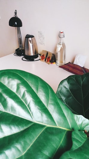 A desk with a kettle, a bottle, and a bag of snacks. - Fish hostel (New Taipei City)