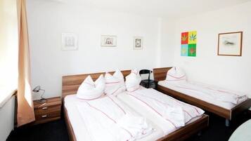 A hotel room with two beds, a wooden headboard, a desk, and a chair.