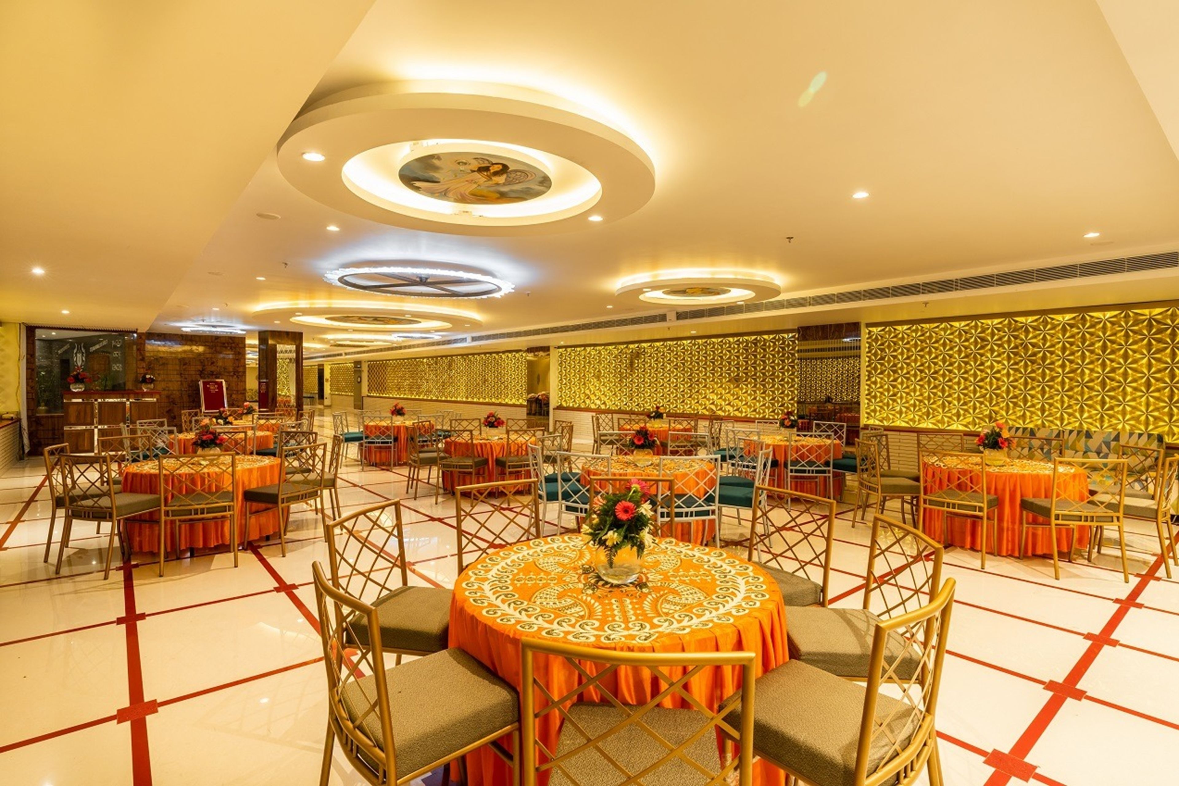 A banquet hall with round tables, chairs, and a decorative ceiling.
