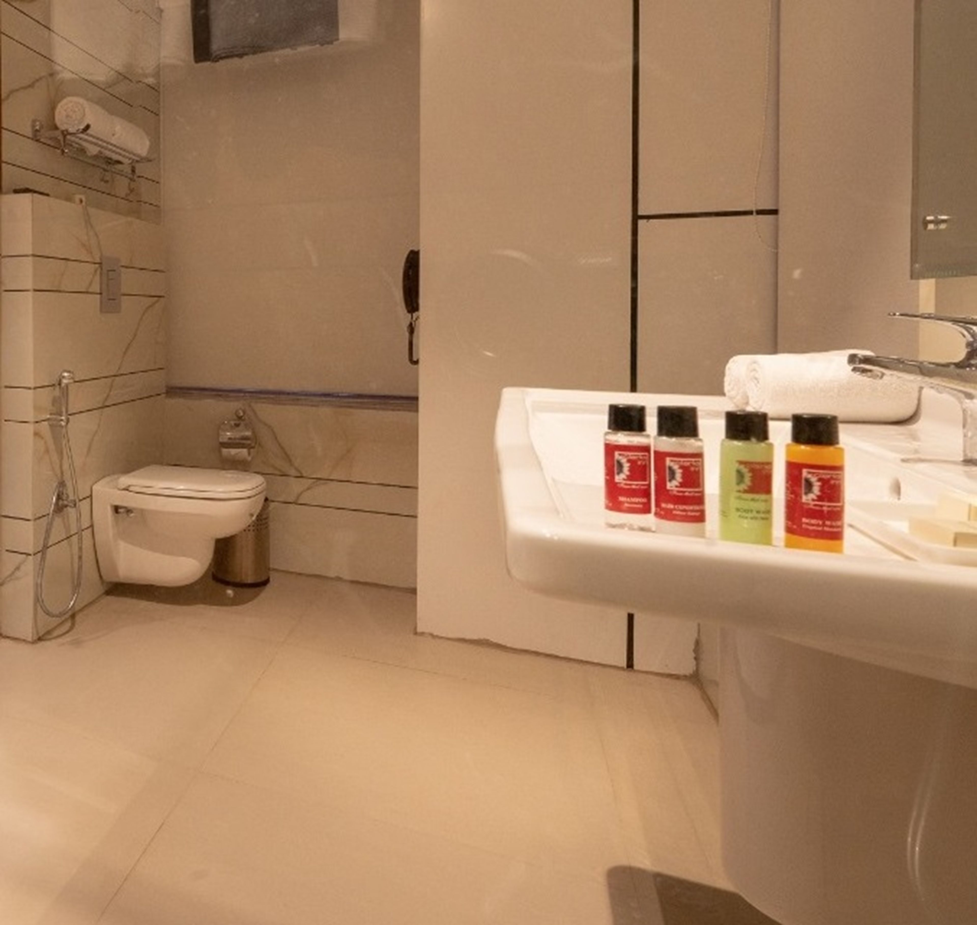 A modern bathroom with a toilet, shower, and sink.