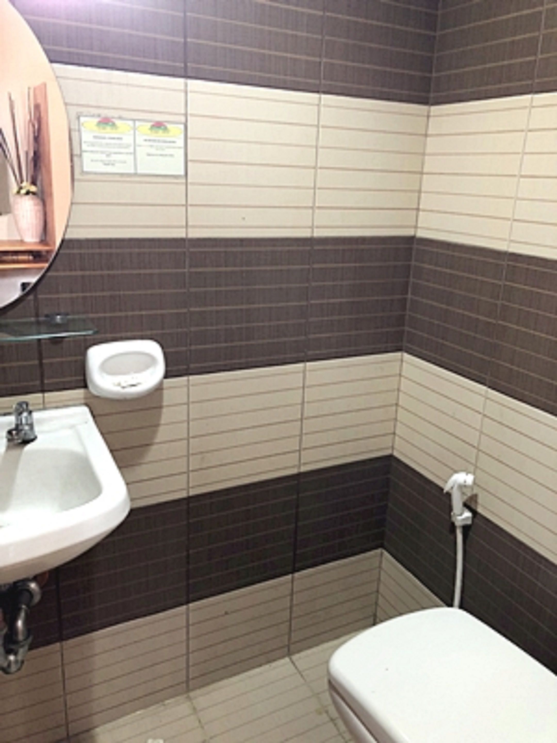 A bathroom with a sink, toilet, and mirror.