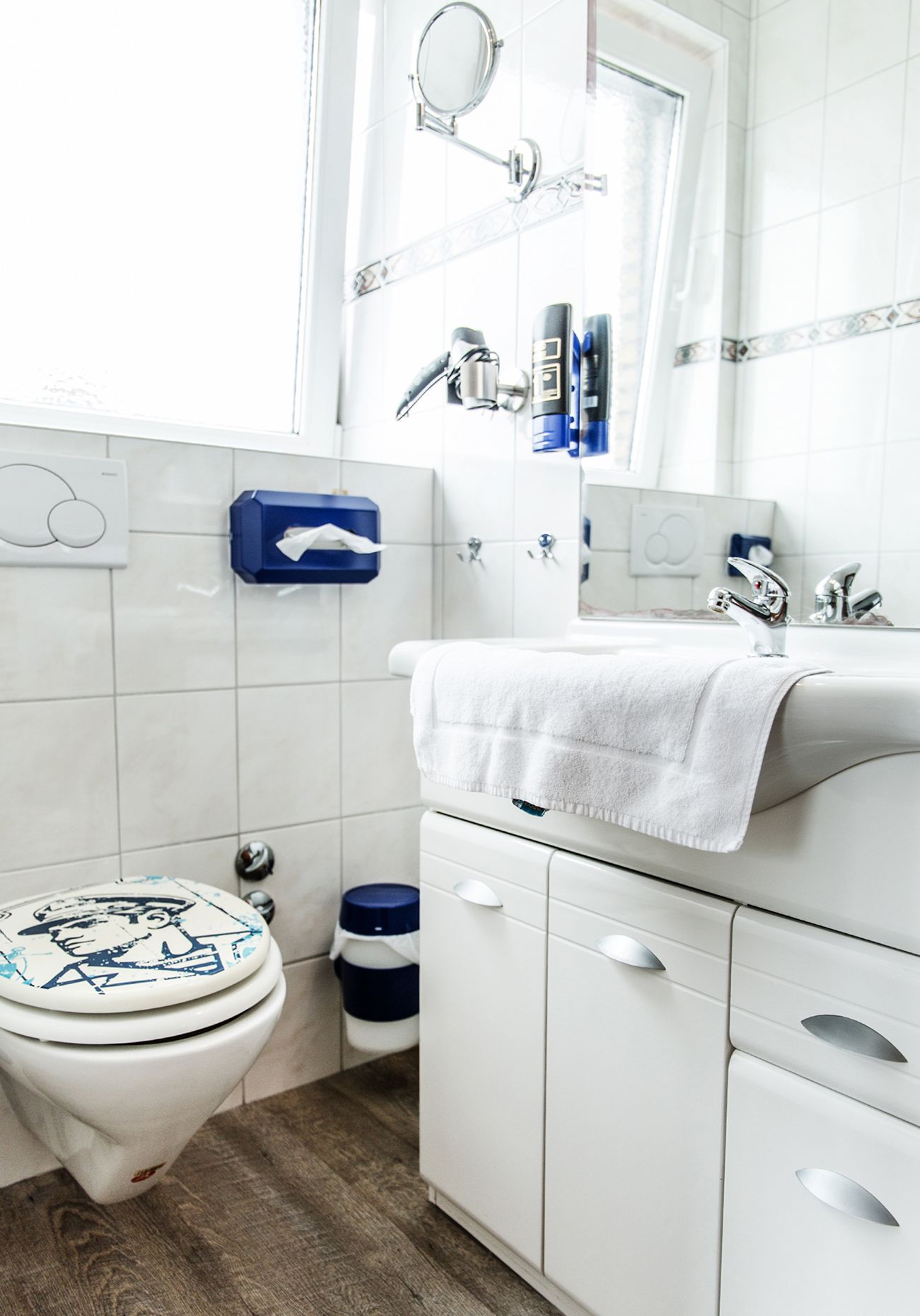 Un baño moderno con inodoro, lavabo y espejo.