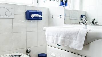 Een moderne badkamer met toilet, wastafel en spiegel.