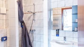 A bathroom with a shower, a sink, and a mirror.