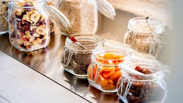 Several glass jars with various food items on a reflective surface.