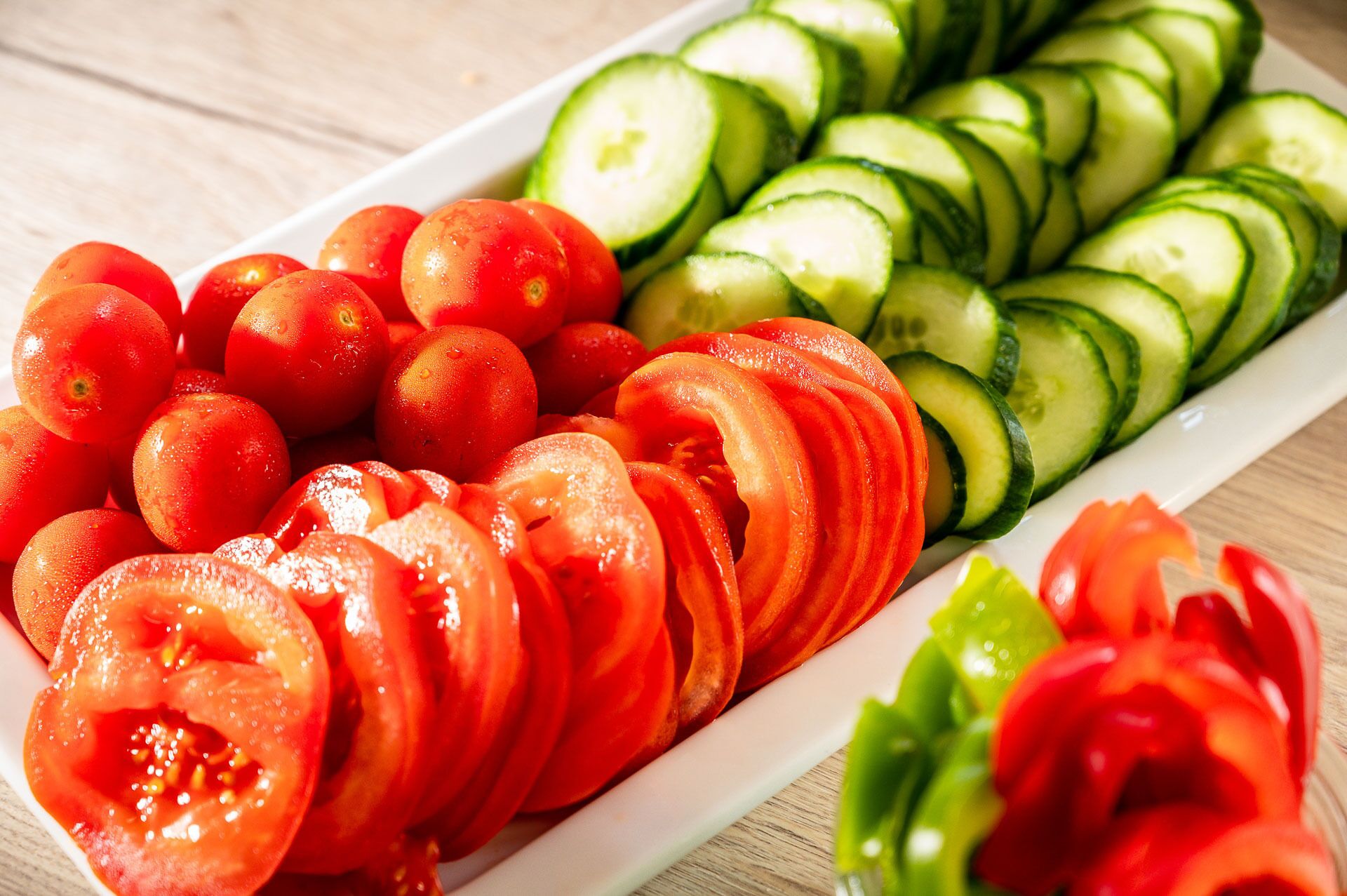 Ein weißer Teller mit Tomaten- und Gurkenscheiben.