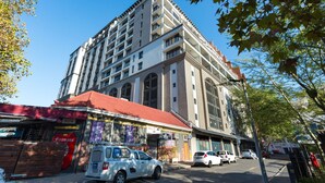 Um edifício de vários andares com telhado vermelho e um letreiro com os dizeres 'Cerveja' e 'Bombeiros'.
