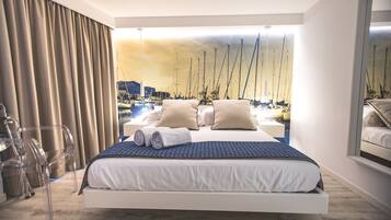 A modern bedroom with a bed, a view of sailboats, and a large window.