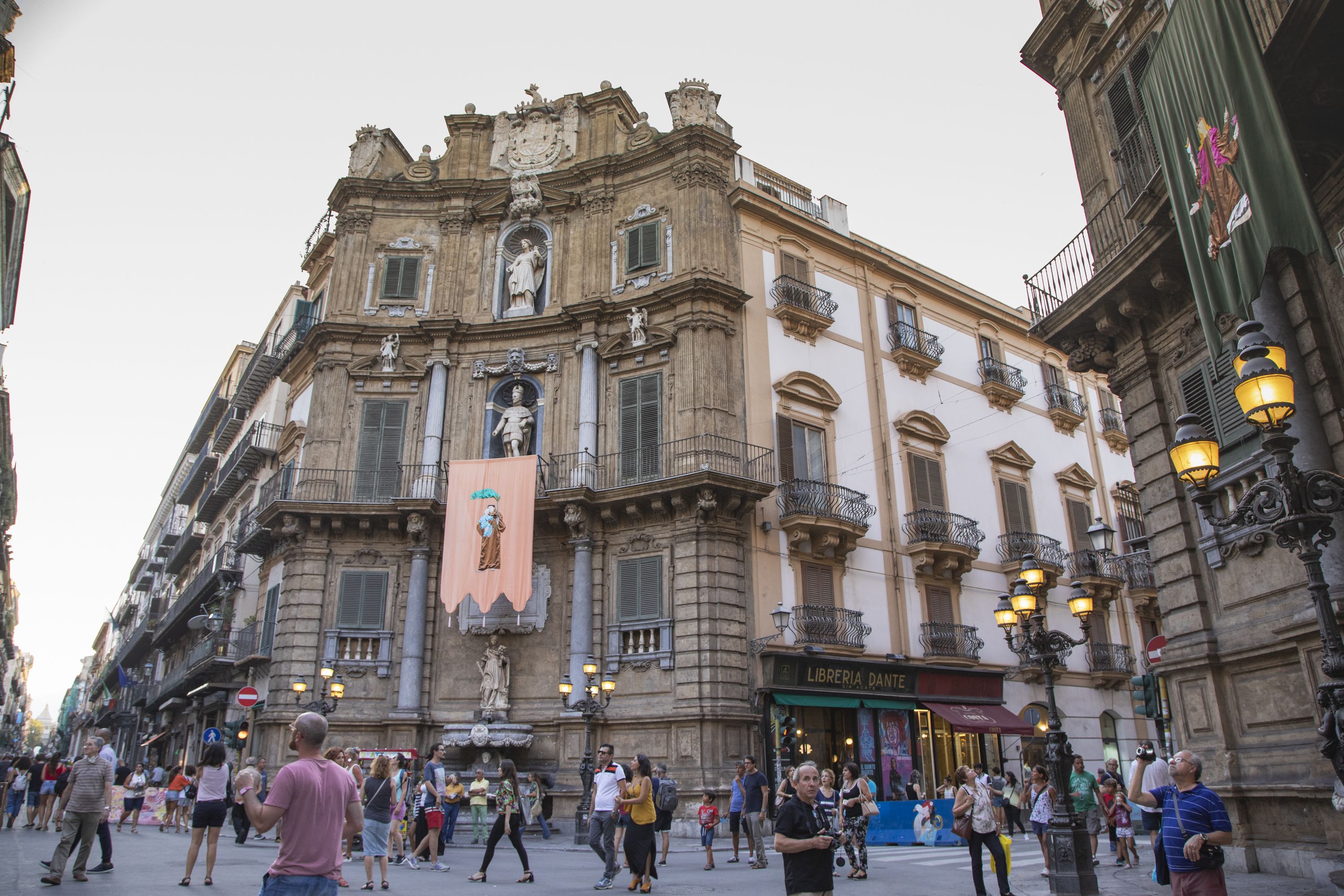 Un edificio histórico con arquitectura ornamentada, una fuente y una tienda Libreria Dante.