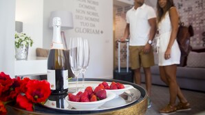 A room with a bottle of champagne, glasses, and strawberries on a tray. There is a wall with a motivational quote. - Thomar Boutique Hotel (Tomar)