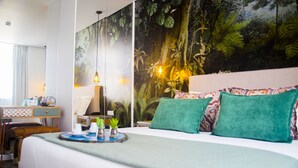 A hotel room with a large bed, a desk with a chair, a small table with a tray, and a mural of a forest on the wall. - Thomar Boutique Hotel (Tomar)