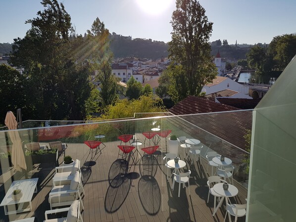 A rooftop terrace with outdoor seating, a view of the city, and a clear sky. - Thomar Boutique Hotel (Tomar)