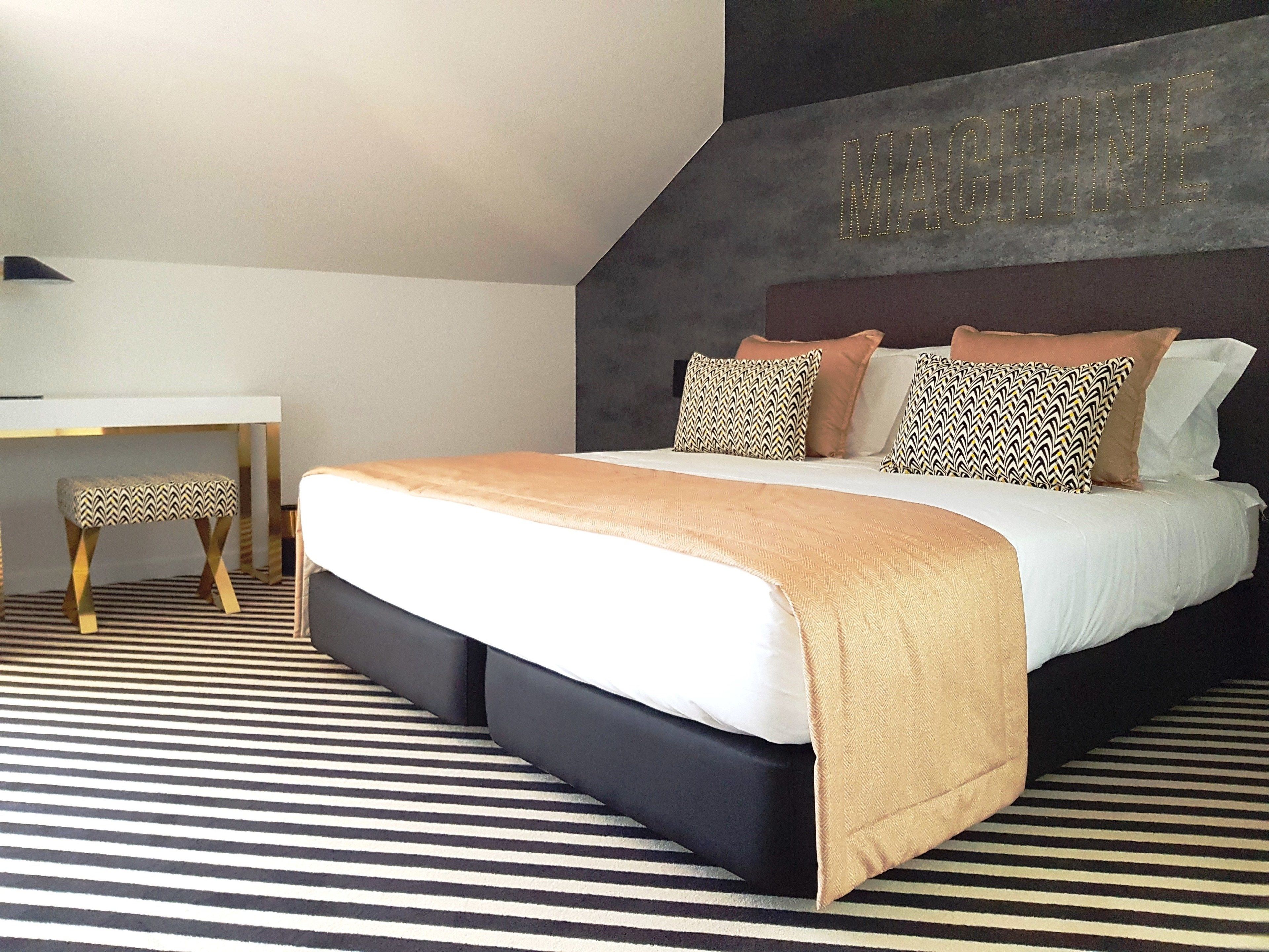 A modern bedroom with a bed, a desk, and a chair.