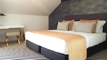 A modern bedroom with a bed, a desk, and a chair.