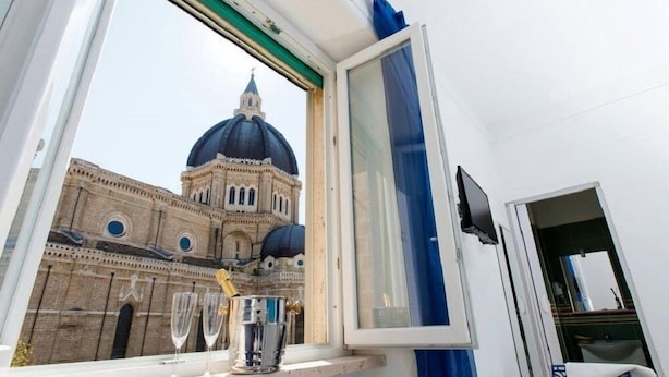 Una habitación con ventana que da a un edificio histórico con cúpula.