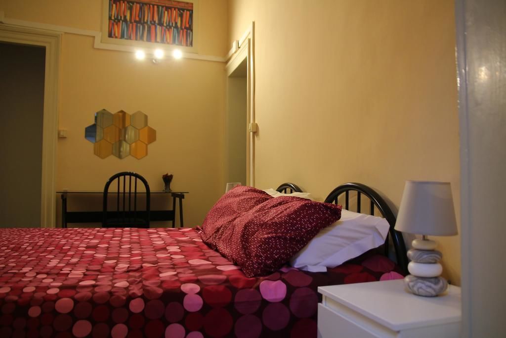 A bedroom with a bed, a chair, a table, and a lamp.