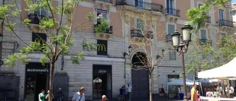 A street scene with a McDonald's restaurant, a closed shop, and a market stall.