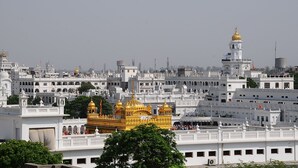 A white building with a golden dome and a flag. - Hotel Sarovar Regency (Amritsar)