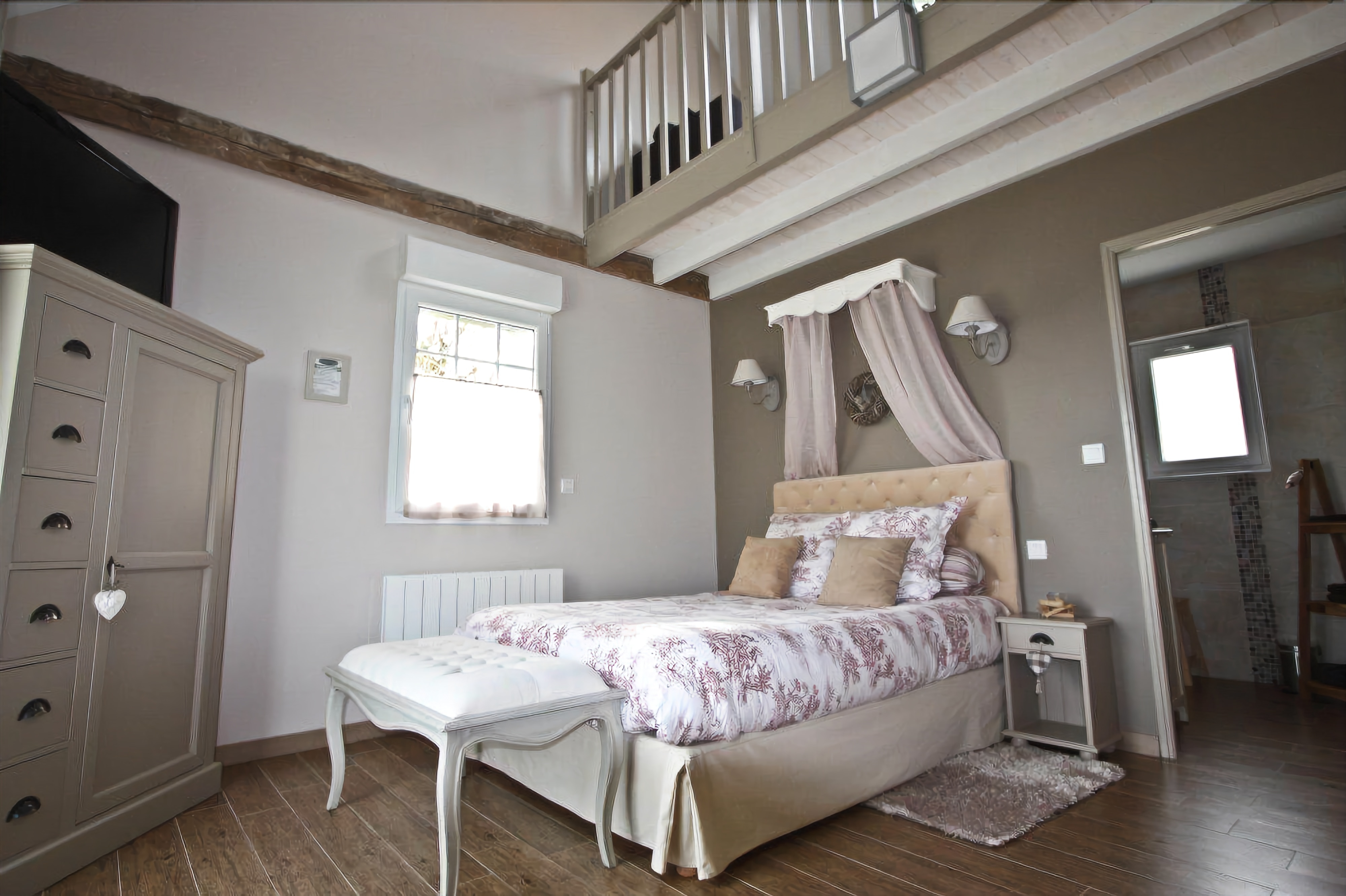 Un dormitorio con cama, mesita de noche, cómoda, ventana y una escalera.
