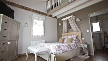 Un dormitorio con cama, mesita de noche, cómoda, ventana y una escalera.