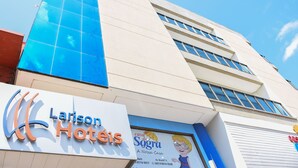 Un letrero de hotel con el nombre 'Larison Hotels' y un letrero más pequeño debajo que anuncia 'Casa da Sogra A Nossa Casa'.