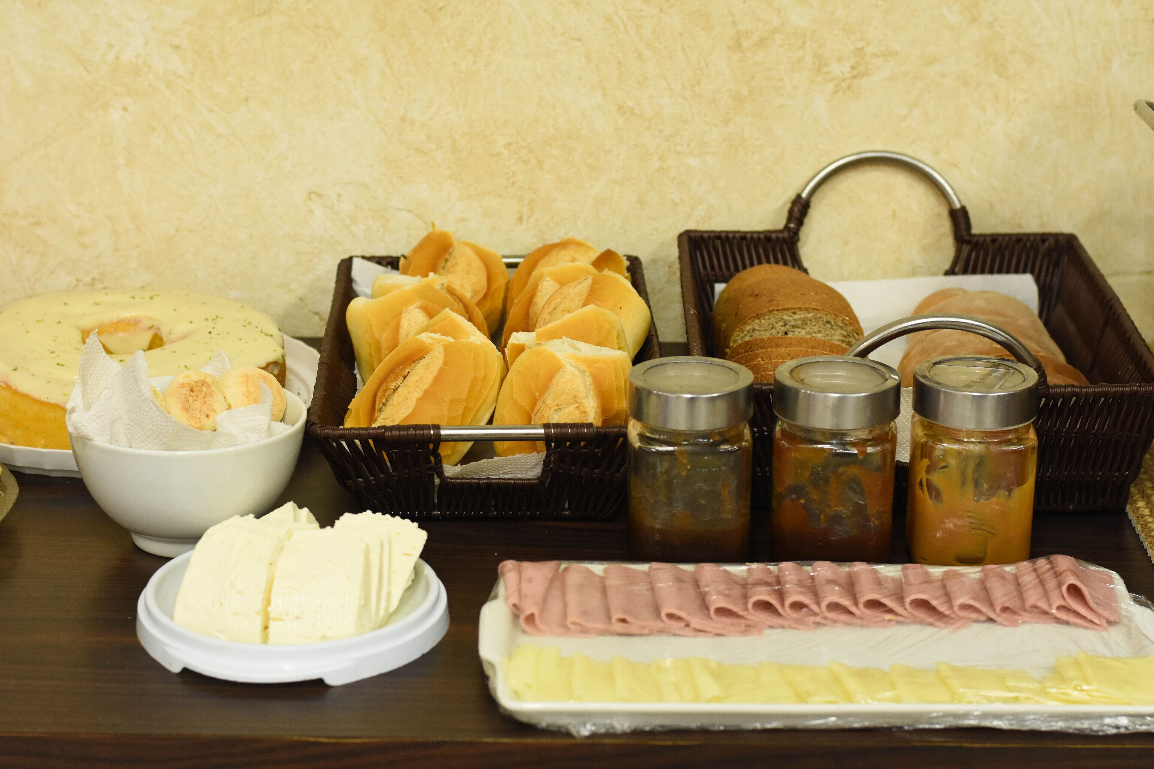 Una mesa con diversos alimentos, como pan, queso y salsas.