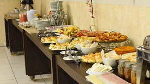 Una mesa de buffet con diversos alimentos y utensilios.