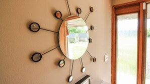 Un espejo montado en la pared con varios espejos más pequeños dispuestos en forma radial.