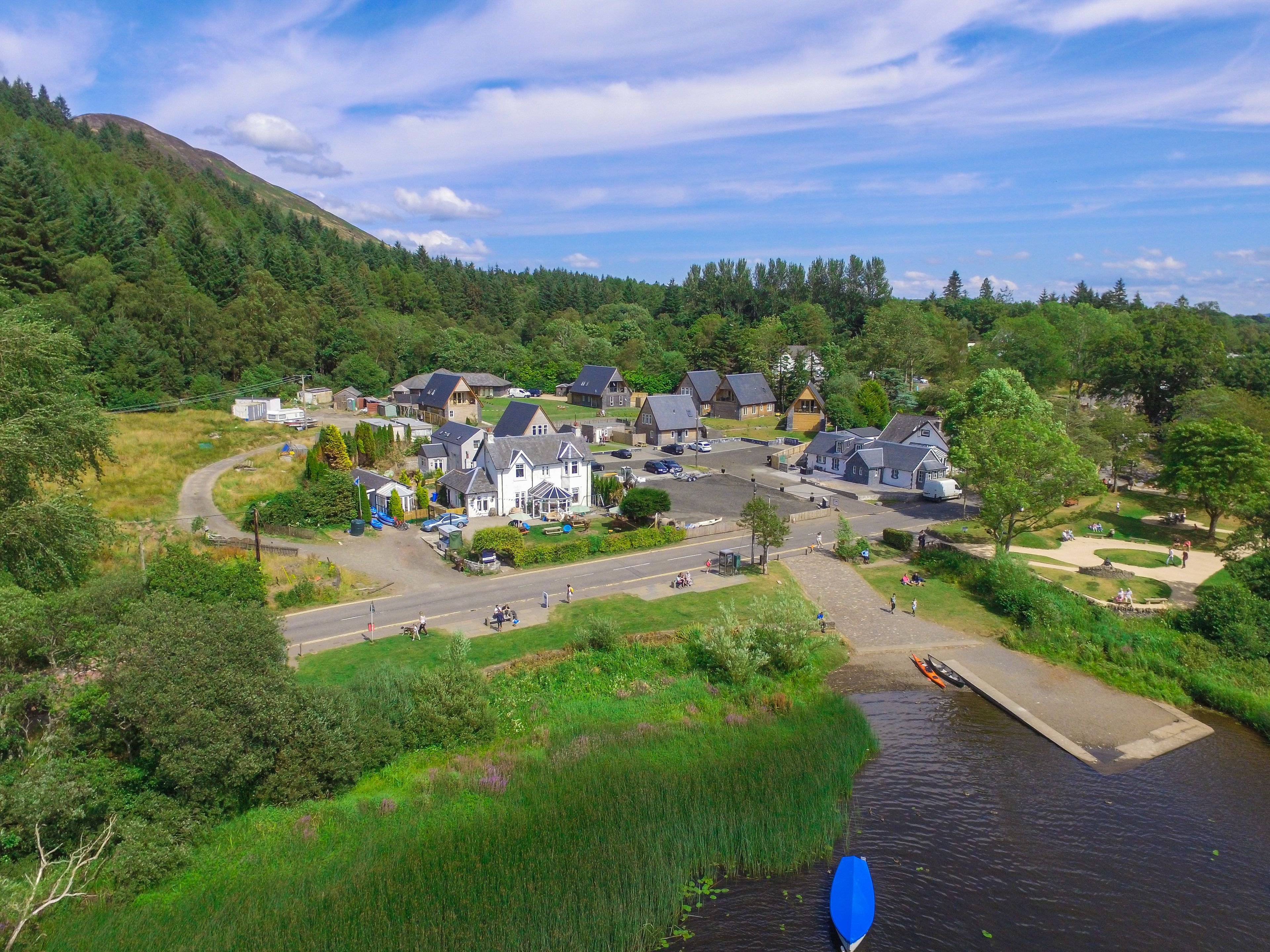 A riverside village with houses, a dock, and a pedestrian path.