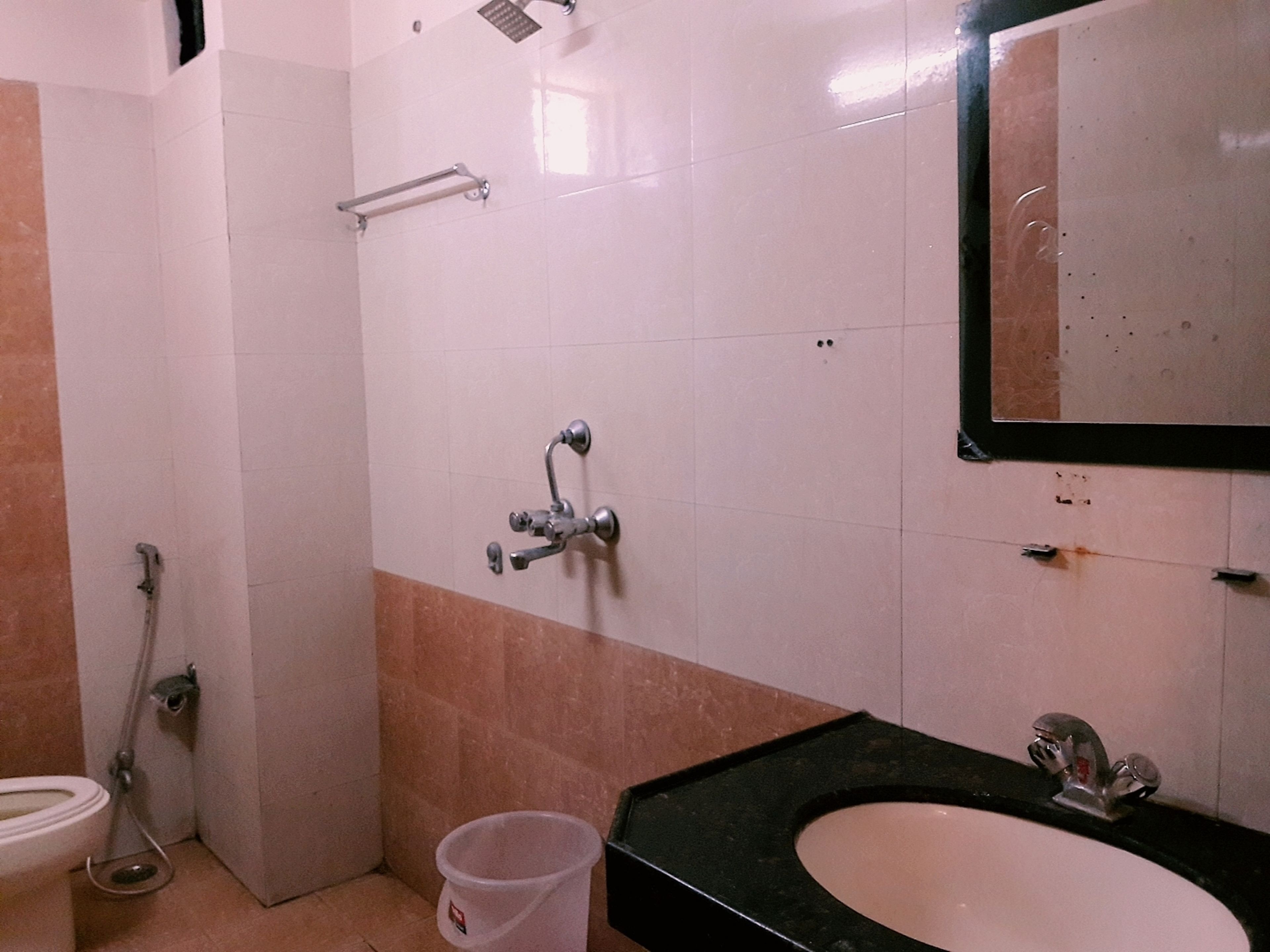 Une salle de bain avec des toilettes, un lavabo et une douche.