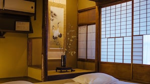 A traditional Japanese-style room with tatami flooring, a shoji screen, and a bed with white bedding. - Gojo Miyabi Inn (Kyoto)