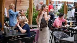 An outdoor seating area with tables and chairs, a wooden pergola, and a sign for Hobson Brewery. - The Falcon Hotel & Restaurant (Bridgnorth)